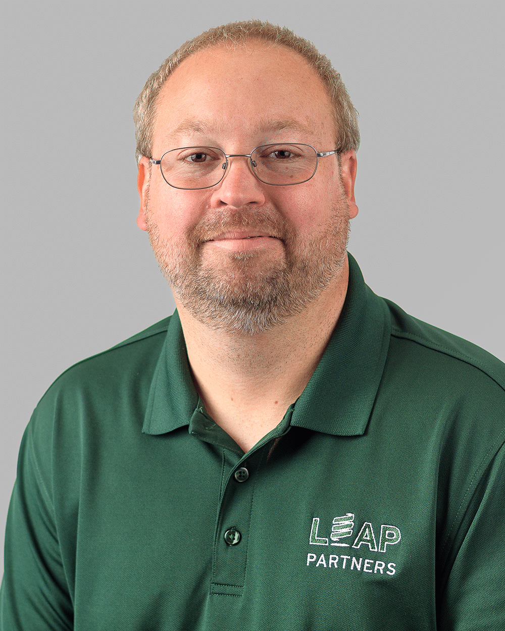 a man wearing glasses and a green shirt