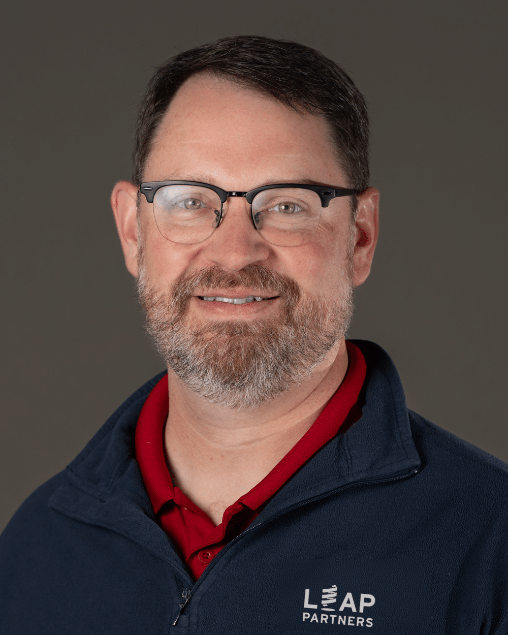 a man wearing glasses and looking at the camera